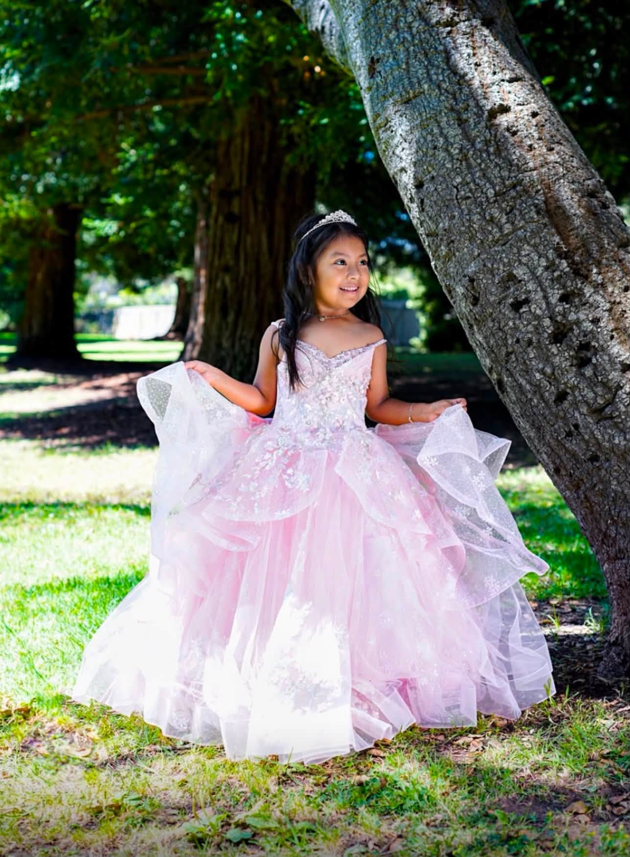 Retrato al aire libre con vestido rosa junto a un árbol
